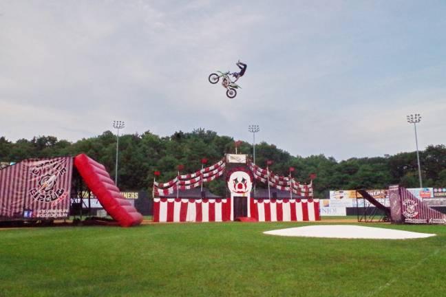 Cycle Circus A motorcyclist in the midst of a high flying stunt.