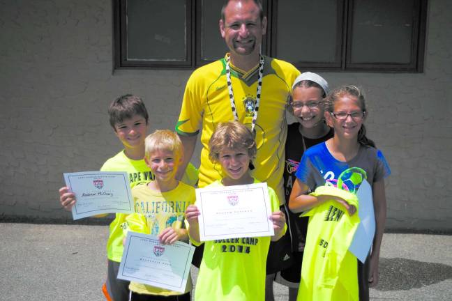 Youngsters learn soccer fundamentals during camp Lenape Valley Regional High School head soccer coach Eric Schuman with camp participants: Andrew McCleary (9), Isaac (8), Andrew (8), Madeleine (11) and Elena (10) Schuman.