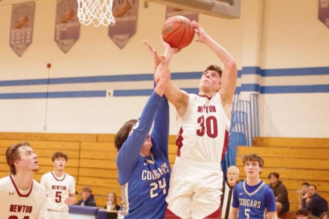 NK3 Newton's Maxwell Maslowski takes the ball toward the hoop. He scored 28 points in the game.