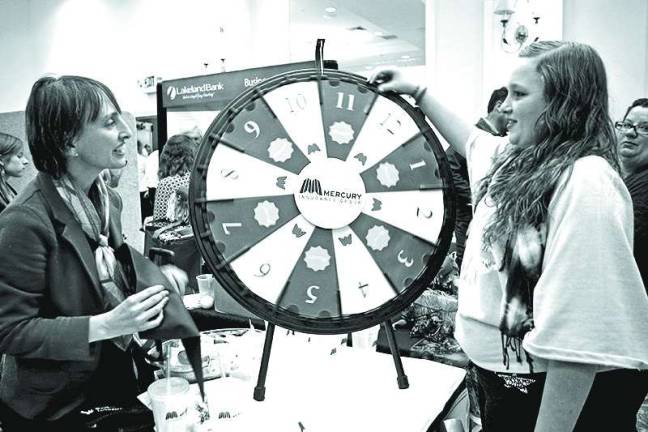 Sussex County chamber hosts business expo At left, Anita Collins of Wantage, of Cotgreave Insurance Agency offered Kendra McCabe of Sussex a chance to spin and win.