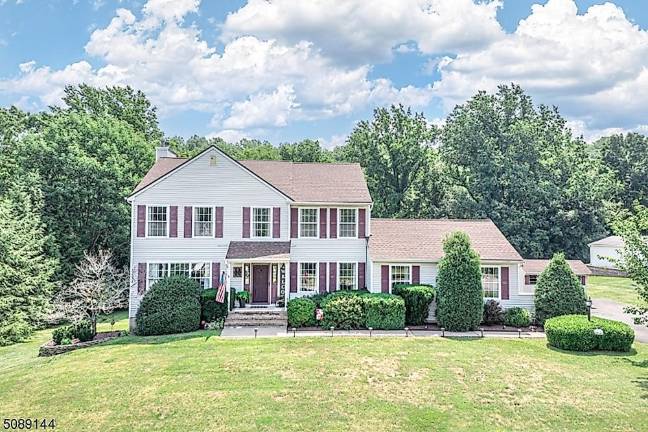 Home with classic beauty is nestled in a mature landscape