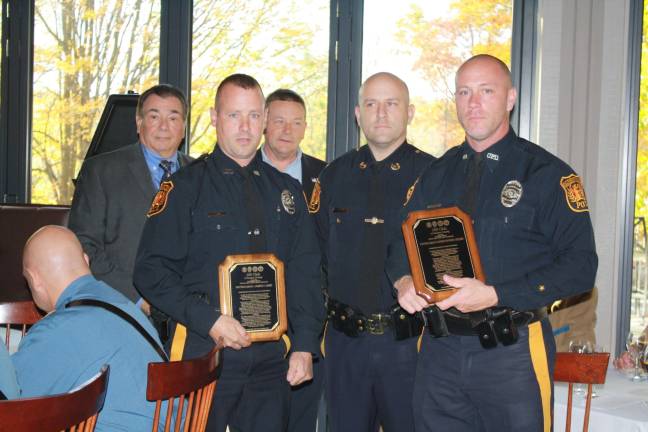 Patrolman James Lame and Patrolman Christopher Geene of Ogdensburg Borough Police Deartment hold their team merit awards. Their Chief Stephen Gordon stands between them, and, from left, 200 Club trustees Pat Aramini and John Drake look on.