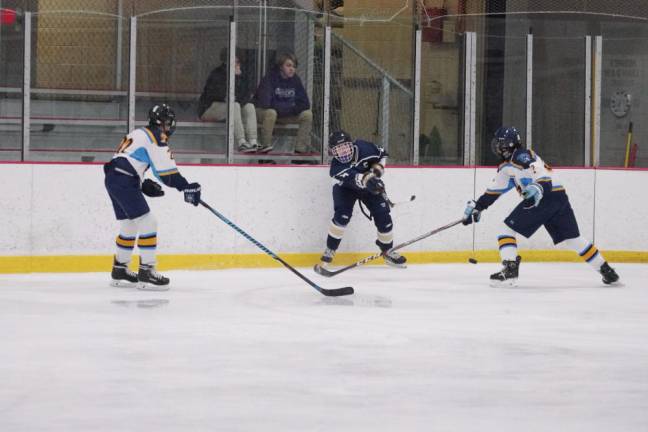 The puck sails through the air between two Sparta-Jefferson United players after being hit by a Roxbury Gael in the first period.