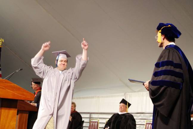 Hats off to SCCC Class of 2017 Sean Lockwood (Associate in Arts) of Vernon Township raises his arms in excitement as he is acknowledged during the graduation ceremony.