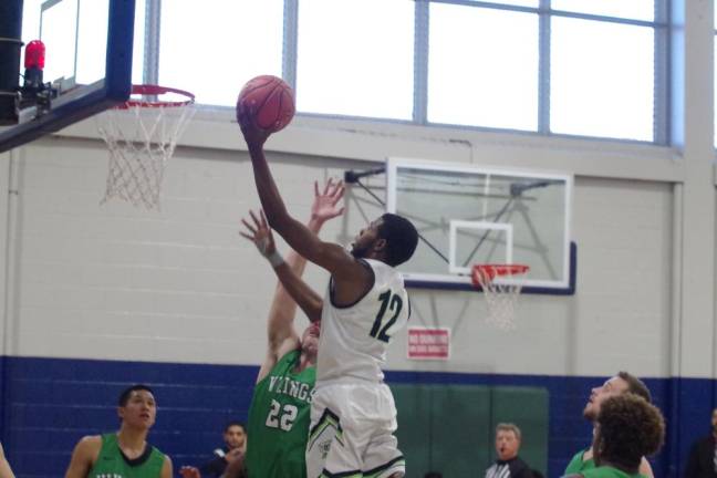 Sussex County's Tamir Williams takes the ball towards the hoop during a leaping shot attempt in the second half.