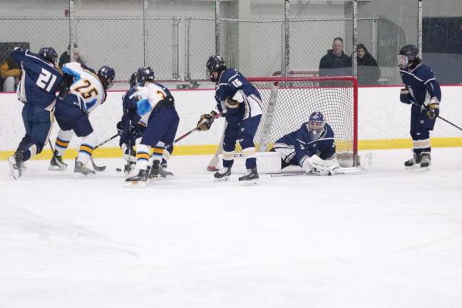Roxbury and Sparta-Jefferson United hockey players battle for control of the puck near the goal post in the first period.