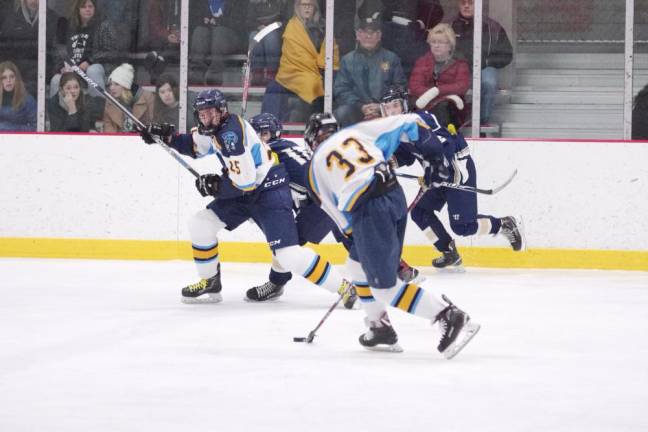 A Sparta-Jefferson United hockey player steers the puck.