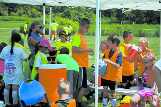 Youngsters learn soccer fundamentals during camp Soccer players during a water break.