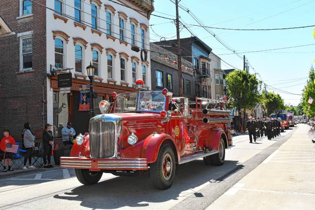 Photos: Memorial Day Parade in Newton An old firetruck is followed by firefighters and newer firetrucks in the parade.