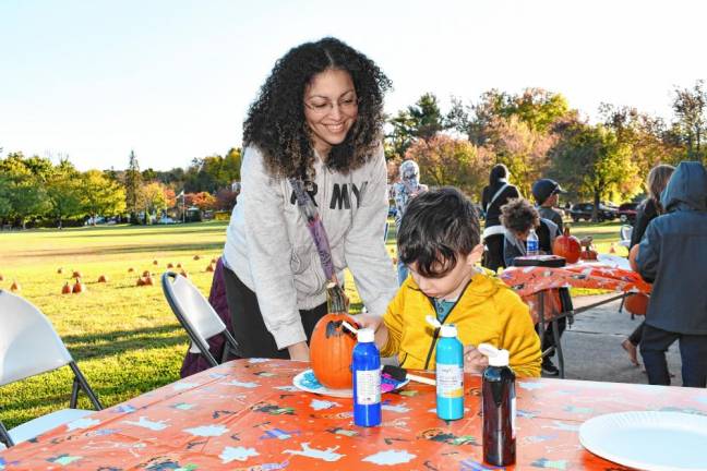 Photos: Norwescap’s Fall Frolic in the Park FF6 Peach Braxton watches Kai Slockbower painting pumpkins. Both are from Vernon.
