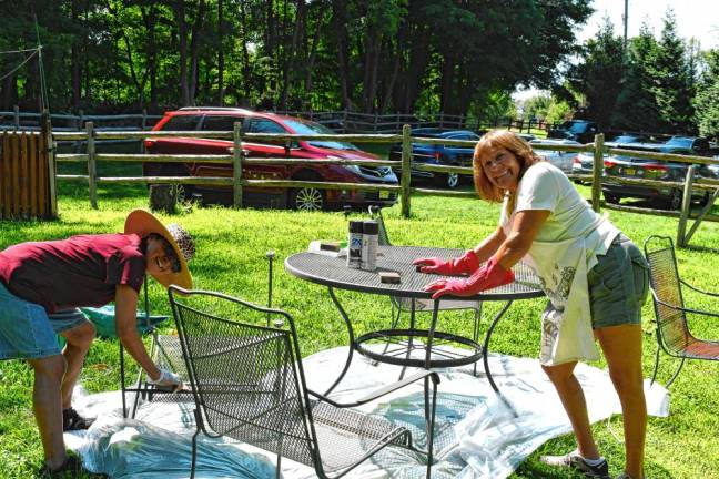 Photos: Volunteer Day at Rebecca’s Homestead <b>Dora Torres of Jefferson and Elisa Young of Oak Ridge paint a table and chairs.</b>