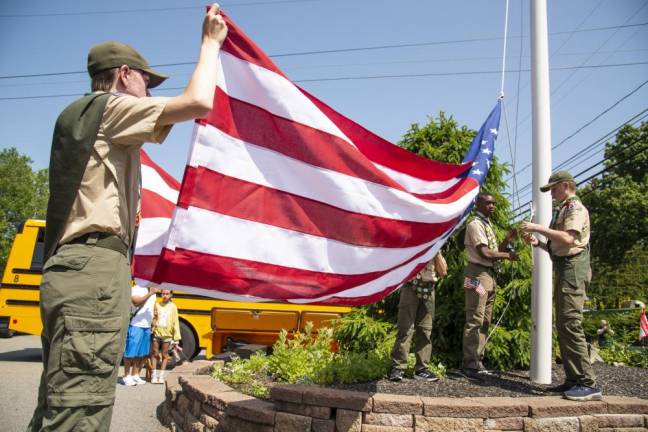 Members of Boy Scout Troop 276 raise the flag at the Byram firehouse before the start of the parade.