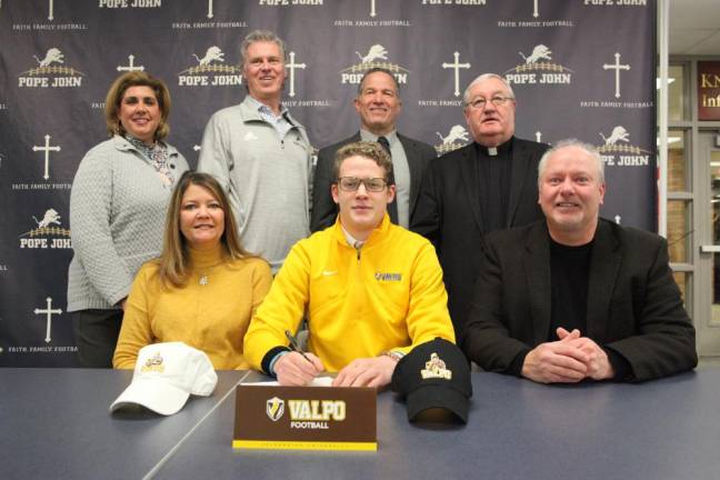 Pope John senior Connor Milks with his parents, Tracy and Don, signs his National Letter of Intent to continue his academic and football careers at Valparaiso University.