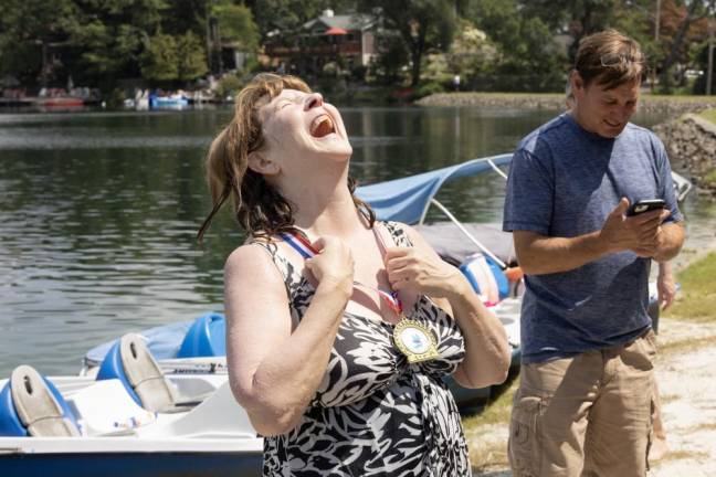 A woman celebrates finishing the 580-meter swim. All participants received a medal.