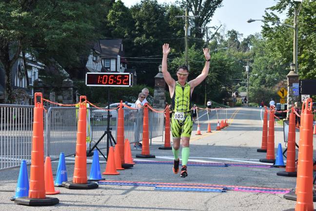 Jon Scott, 51, of Sparta, crosses the finish line with a finish time of just over an hour and six minutes.