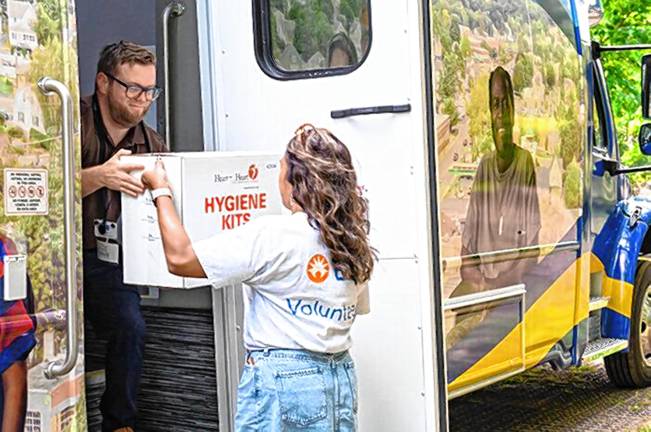 Zufall readies new mobile medical unit Volunteer Lindsay Benoza-Morales hands a box of hygiene kits packed by BD volunteers to Zufall fleet coordinator Jorge Castro for delivery to patients via the mobile unit.