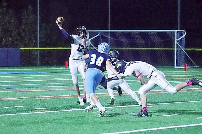 Jefferson quarterback Erik Garv is in the midst of throwing the ball while under pressure by Sparta defenders in the second quarter (George Leroy Hunter)