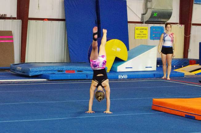 Skills clinic readies gymnasts Gymnast Rebecca Lange (11) does a hand stand during a floor routine.