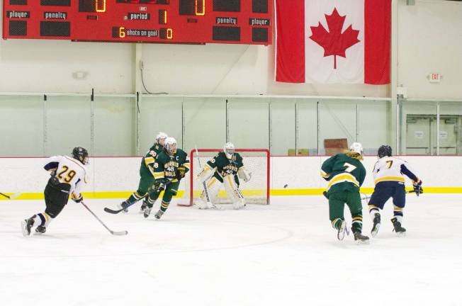 The puck is airborne heading for the Morris Knolls goal. Photos by George Leroy Hunter