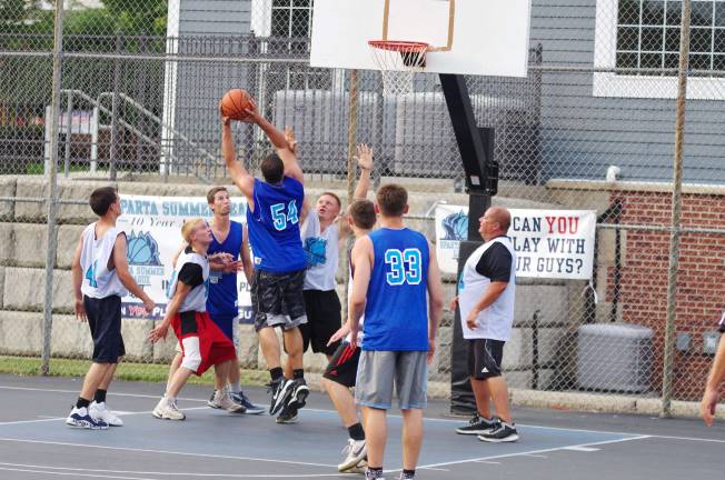 Smalley beats Basket in summer basketball Team Smalley (blue) and Team Basket battle on the court. Photos by George Leroy Hunter