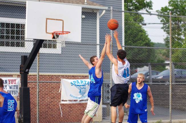 Smalley beats Basket in summer basketball Team Smalley's Colby Thomas tries to block the ball launched by Team Basket's Luke Basket (41).