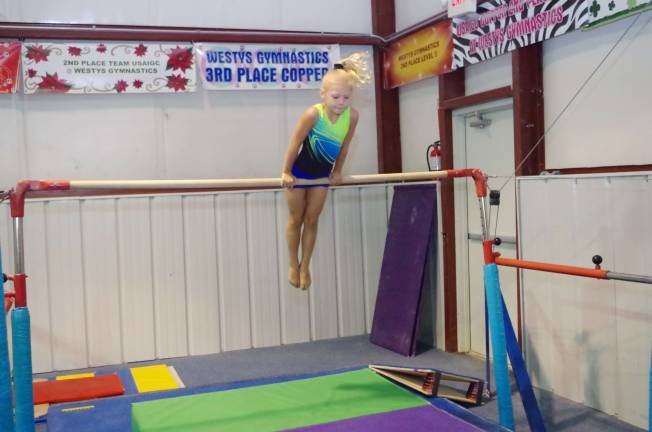 Skills clinic readies gymnasts Six year old Hailey Jenkins performs on the uneven bars.
