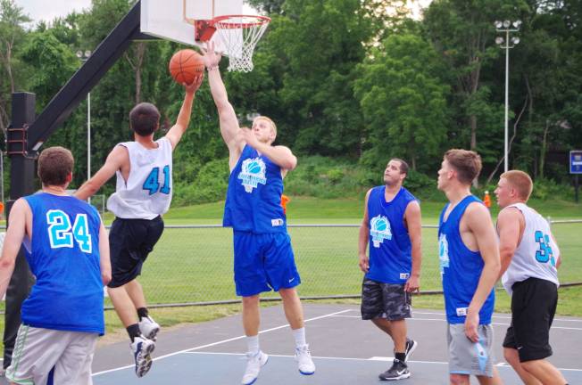 Smalley beats Basket in summer basketball Team Basket's Luke Basket rises during a shot as Team Smalley's Derek Hall reaches towards the ball to block it.