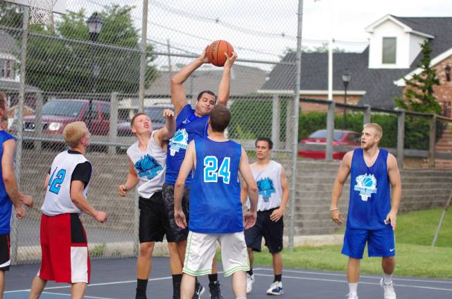 Smalley beats Basket in summer basketball Team Smalley's John Smalley grabs the ball during a rebound.