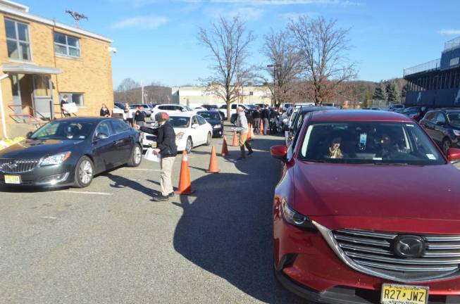 A line of car awaits being loaded up with Thanksgiving meal items to be delivered.