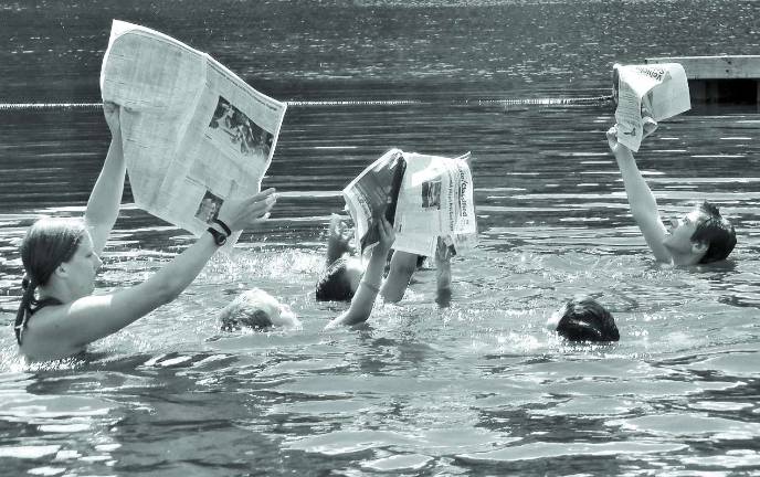 College student reinvents swim day Jill Tracey, far left, holds a newspaper above the water for a Swim Day contest