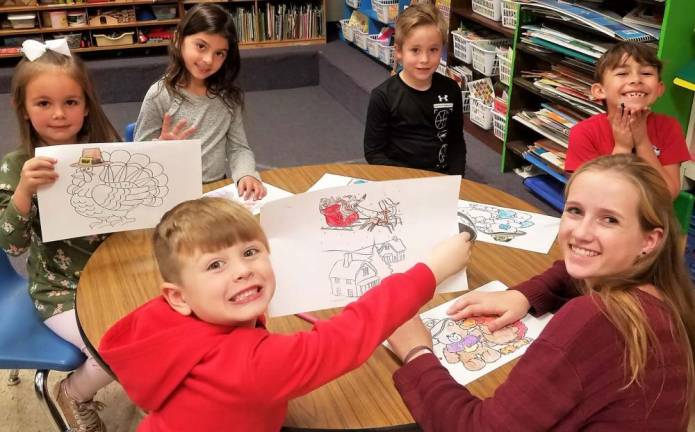 Members of the Kittatinny InterAct Club color Santa and Thanksgiving placemats. The children are learning about community service.