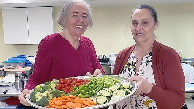 From basketball to sock soccer: Outreach Sports gets kids and adults moving Connie Smith and Kathy McNickle have volunteered in the kitchen for the program since its inception (Photo by Laurie Gordon)