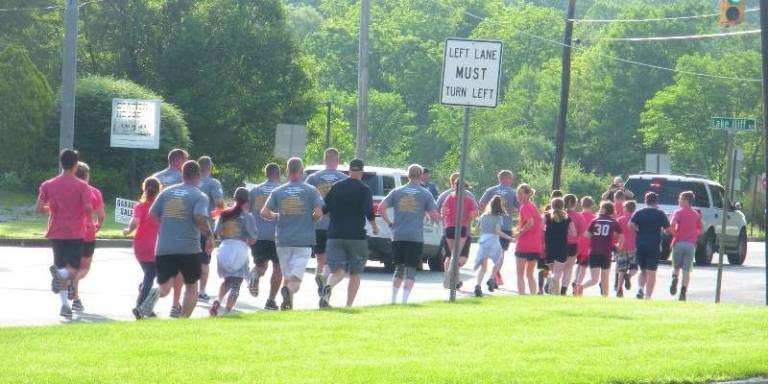 Long Pond School takes part in Torch Run Runners from the police departments and schools in Newton and Andover make their way up Newton-Sparta Road.