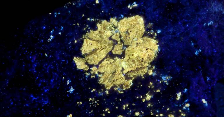 Treasure hunt A mineral rock displays a flower shape pattern under a special black light.