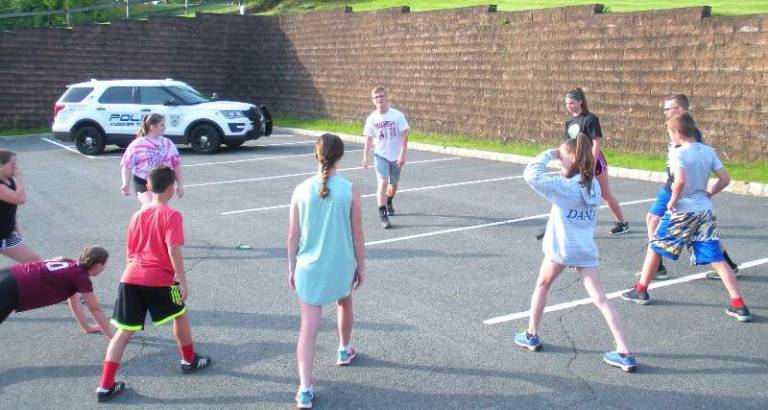 Long Pond School 8th-grader Adam Kesselman (center) leads his schoolmates in a series of stretches before the run.