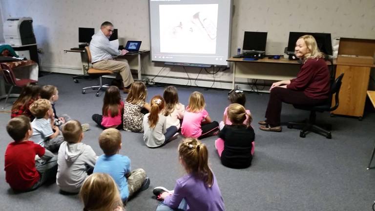 Music teachers volunteer at Auxilium School Robert and Hortense Civiletti instruct The Auxilium School students on the many different instruments and the sounds they make.