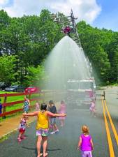 Children cool off in the spray from a firetruck hose during the Stanhope Family Fun Day on Saturday, July 15. (Photos by Greg Smith)