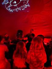 LIB1 Robert Teeter of Pearl Observatory uses red lights to show the effect of light pollution in an inflatable planetarium June 24 at the Main Library in Newton. (Photo courtesy of Sussex County Library System)