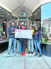 Jennifer Shotwell, center, wins $25,000 in a fundraising raffle benefiting Benny’s Bodega in Newton. (Photo provided)