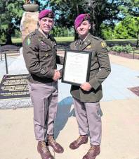 Stephen Rozek of Andover, right, poses with another officer and a certificate signifying his promotion to captain in the U.S. Army.