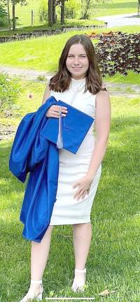 Megan Halpin stands with her cap and gown, ready to move on to Michigan State University.