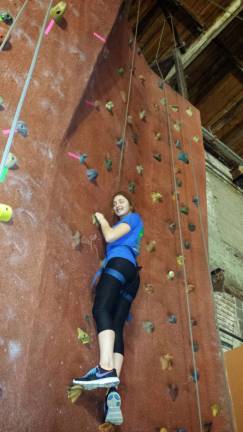 Crew Member Jennifer Sarcona climbing a rock wall.