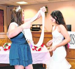Miss Andover 2025 Chesney Walsh puts the sash on Miss Andover 2026 Sadie Fagerlin.