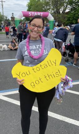 Jill Steffens, mother and coach of the GOTR chapter at Sussex County Charter School for Technology in Sparta, holds an encouraging sign.