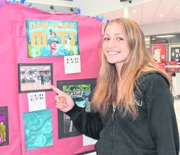 Mariana Akerman points at her artwork.