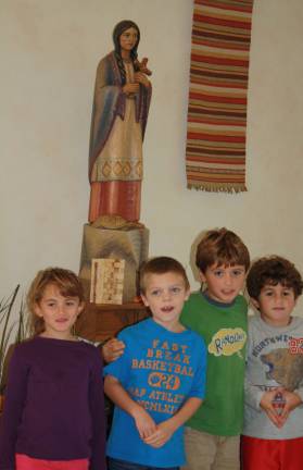 Children from Saint Kateri Tekakwitha in front of a statue of the newly cannonized saint