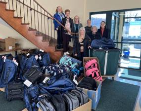 Members of the Newton Rotary Club donate bags packed with supplies for the homeless to Project Self-Sufficiency.