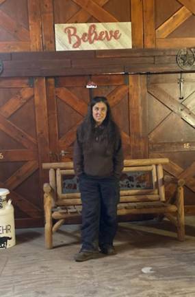 Diane Romano in the barn under her 'Believe' sign. She believes the sanctuary can persevere.