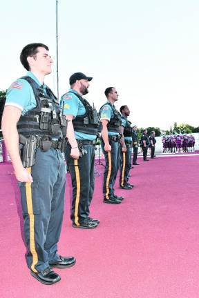 The police stand at attention as the Newton Braves take the field.