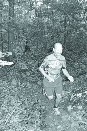 Robbie Davidson, Founder and President of the Salt Shakers, makes his way through the woods during a trail run.